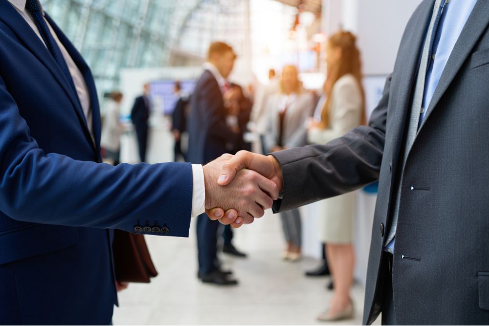 Poignée de main lors d'un salon professionnel de la copropriété symbolisant le partenariat